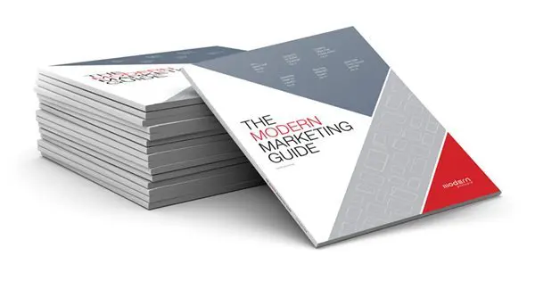 stack of modern marketing guide booklets