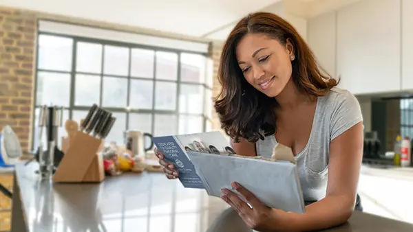 A woman reading direct mail in her kitchen