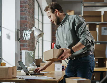 Church direct mail marketing postcard examples eCommerce business owner on the computer packing an order