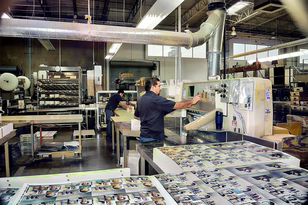 Modern Postcard employee working on bindery equipment