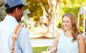 a postal working delivering mail directly to a woman