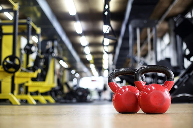 Gym with red barbells in the foreground
