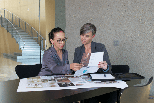 two people reviewing direct mail marketing pieces in an office